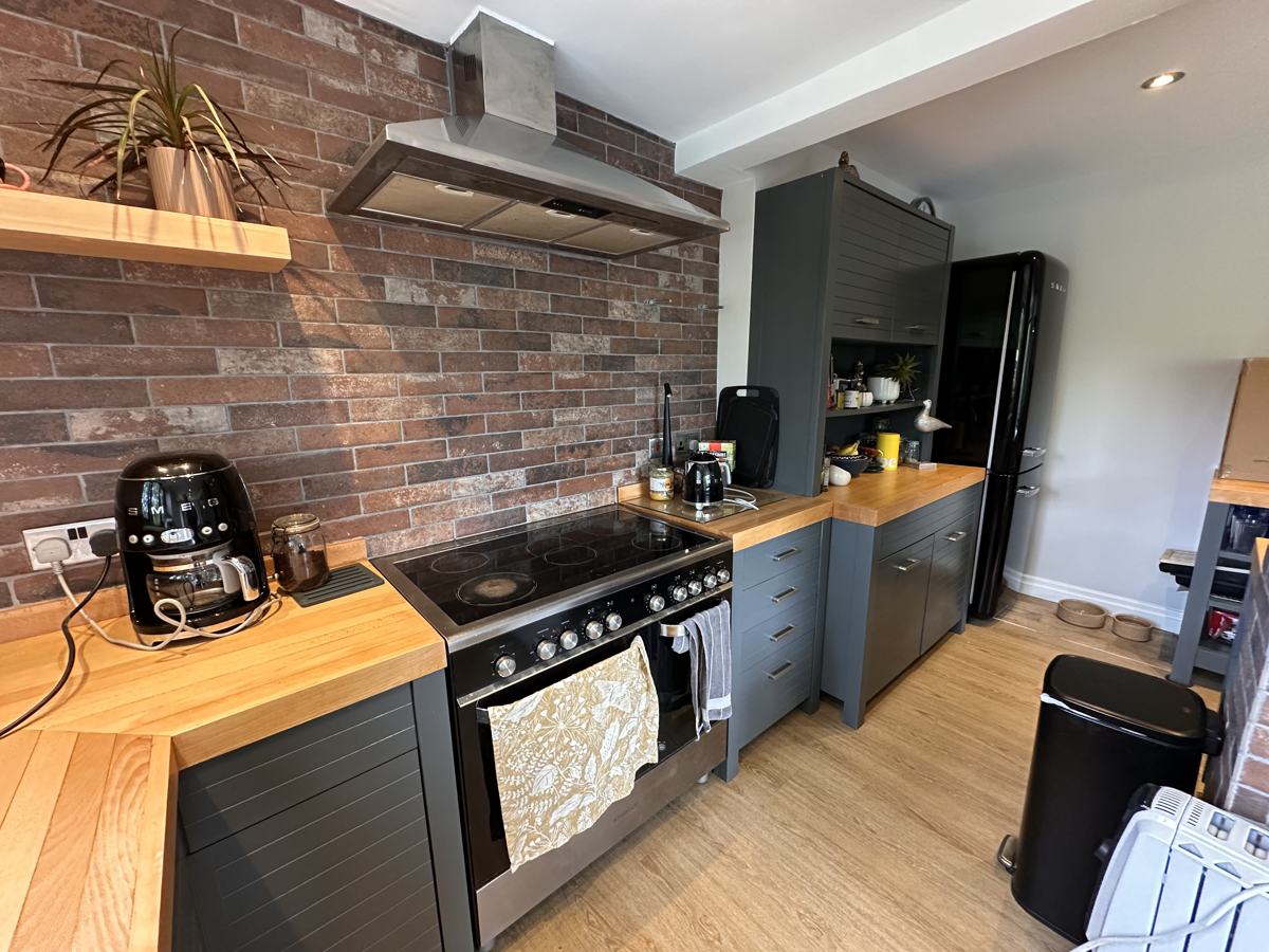 Delph kitchen after: dark grey units, exposed brick and oak worktops