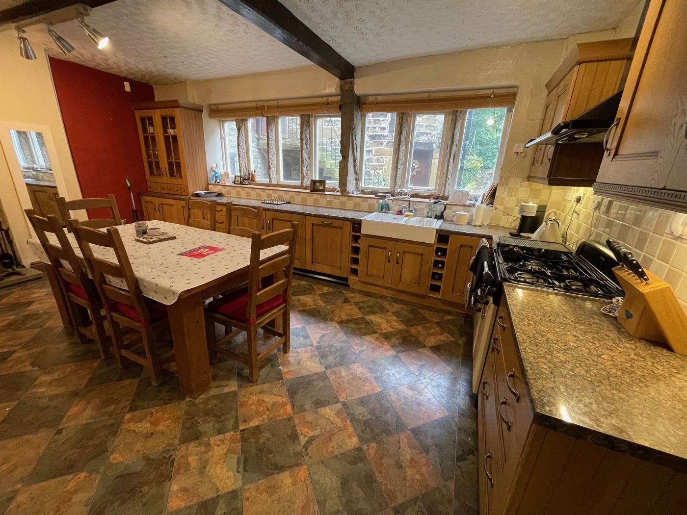 Farmhouse kitchen before: orange oak units, red wall and patterned floor