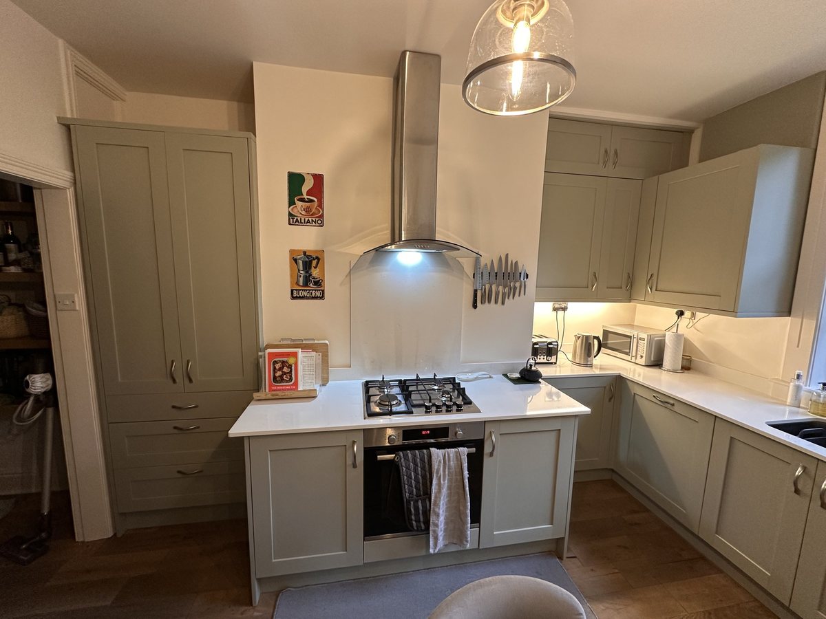 Cooker wall after: sage green shaker units, Carrara Classic quartz worktops and glass splashback