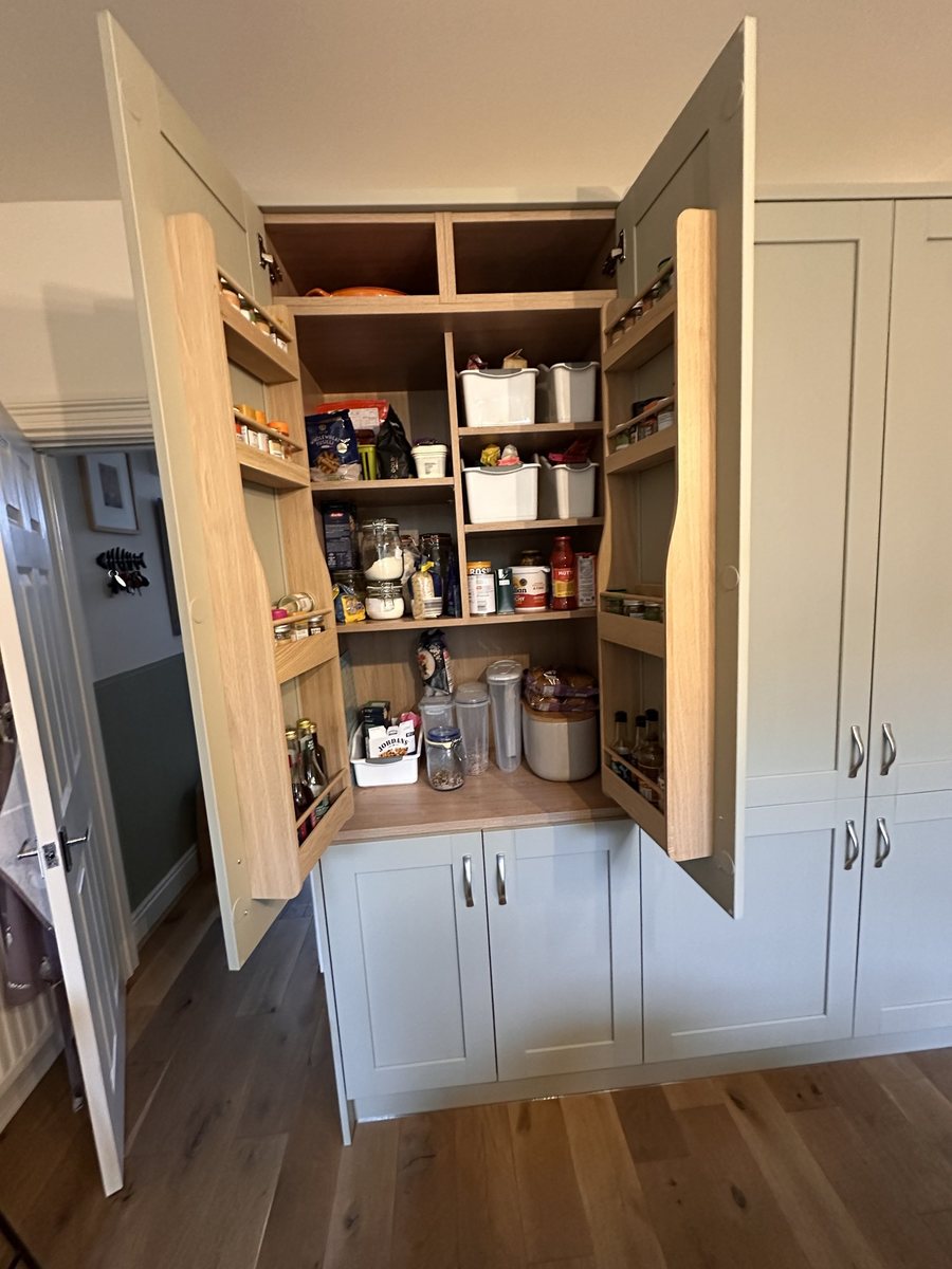 Larder pantry with oak shelves and spice racks in the doors