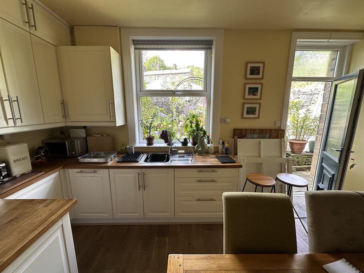 Sink wall before: cream units and wooden worktops