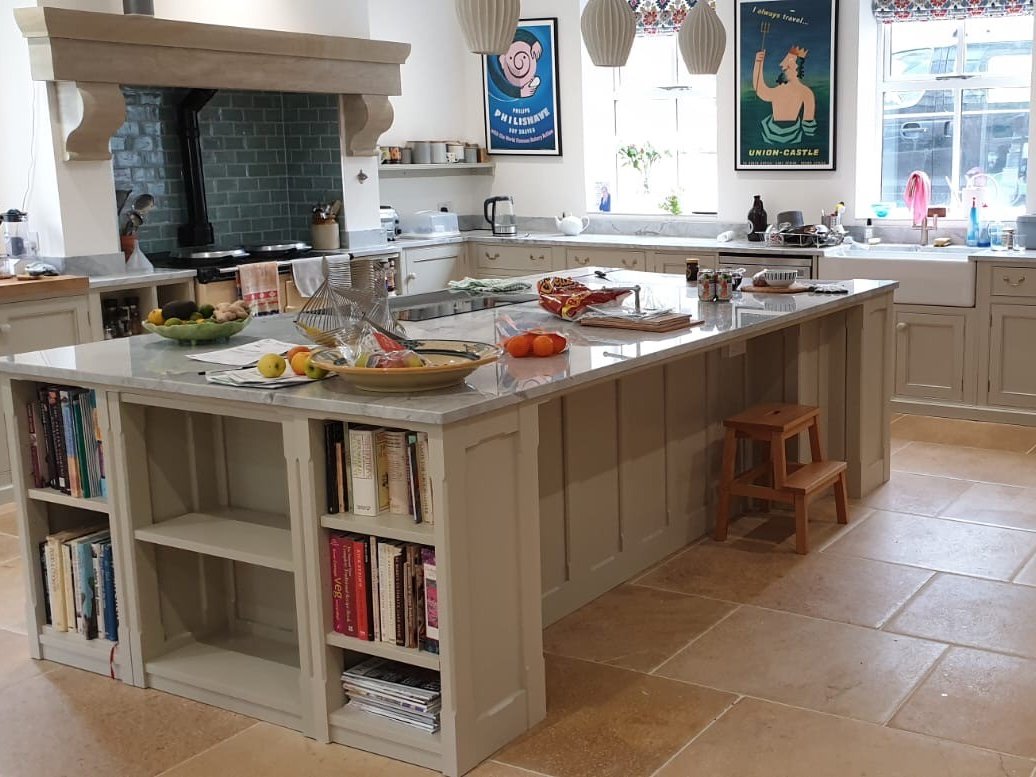 The finished island with open shelves for cookbooks and a stone worktop
