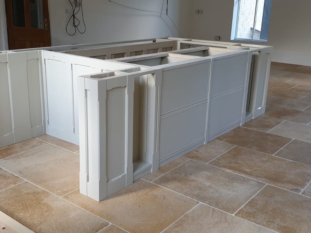 The painted island units being fitted in the kitchen
