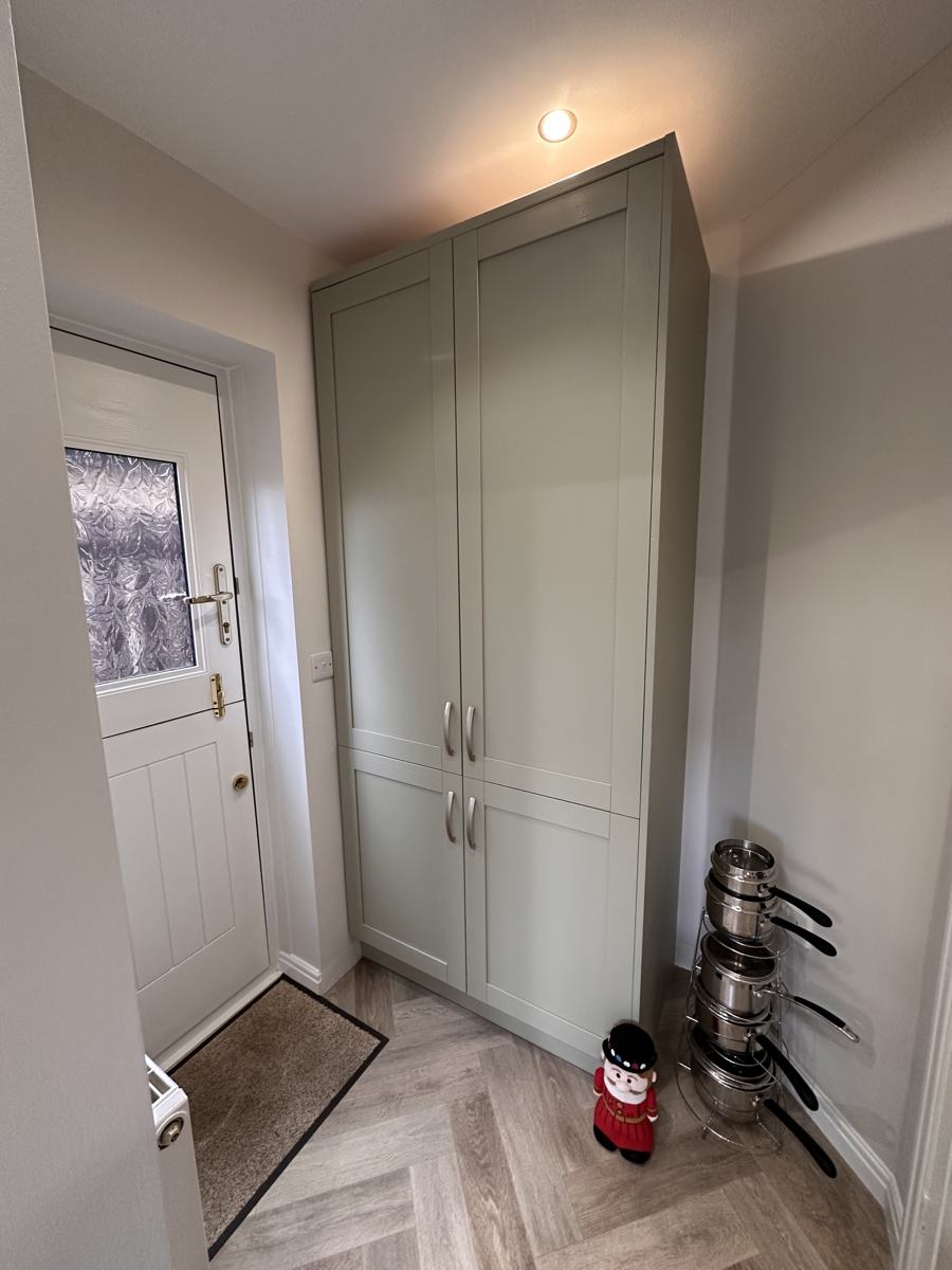 Utility area after: a tall sage green pantry unit